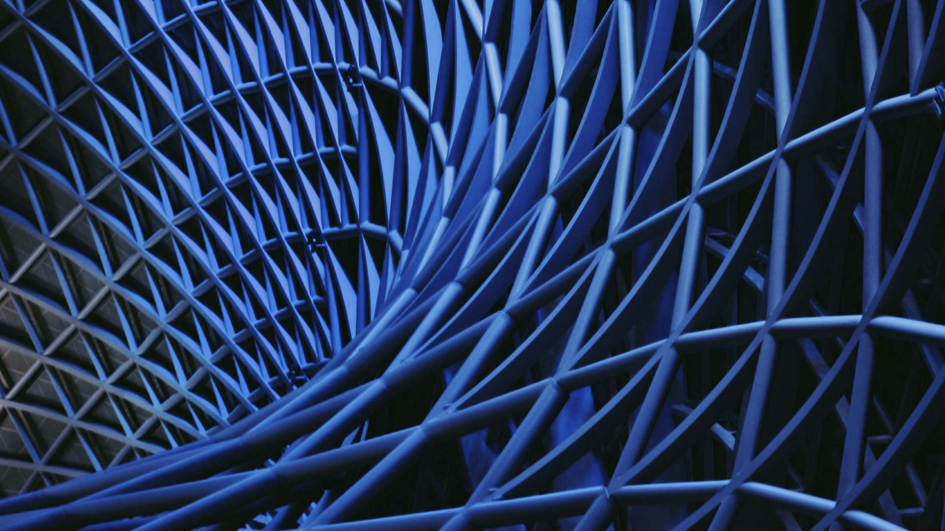 Close-up of a blue metal lattice with diagonal bars creating a crisscross pattern.